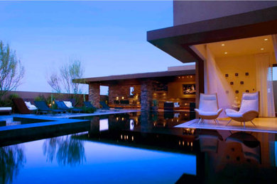 Идея дизайна: бассейн-инфинити произвольной формы на заднем дворе в стиле модернизм с джакузи