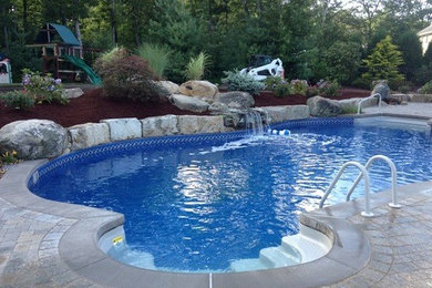 Large indoor concrete paver and custom-shaped pool fountain photo in Manchester