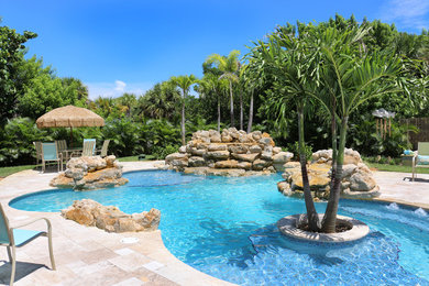Island style custom-shaped natural pool photo in Miami