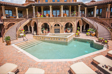 Example of a huge tuscan backyard brick and kidney-shaped natural pool design in Denver