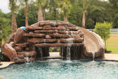 Large island style pool photo in Houston