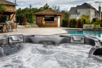 Foto di una grande piscina fuori terra classica rettangolare dietro casa con una vasca idromassaggio