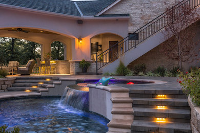 Diseño de piscina con fuente alargada actual a medida en patio trasero con adoquines de hormigón
