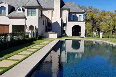 Example of a large backyard stone and custom-shaped pool design in Other