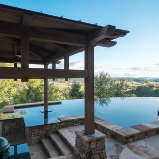 Ispirazione per una piscina a sfioro infinito rustica personalizzata dietro casa con piastrelle
