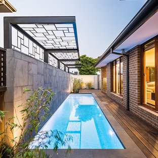 Ejemplo de piscina alargada, actual, pequeña, rectangular, en patio lateral, con entablado