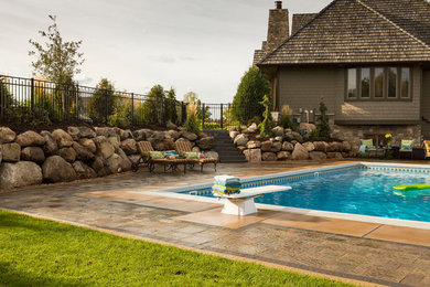 Example of a mid-sized classic backyard stone and rectangular lap pool design