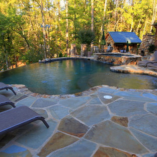 Großer Rustikaler Infinity-Pool hinter dem Haus in individueller Form mit Poolhaus und Natursteinplatten in Sonstige