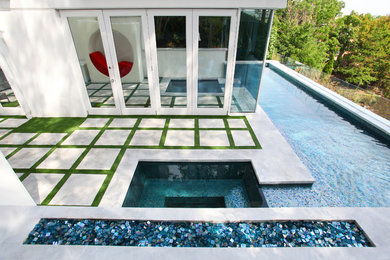 Idée de décoration pour un grand couloir de nage latéral minimaliste en L avec un bain bouillonnant et une dalle de béton.