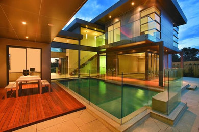 Mittelgroßes Modernes Sportbecken hinter dem Haus in rechteckiger Form mit Dielen in Sydney