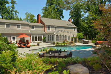 Inspiration for a large timeless backyard concrete paver and custom-shaped lap pool remodel in Baltimore