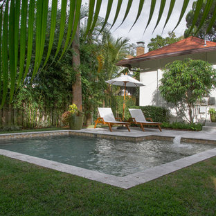 Modelo de piscinas y jacuzzis naturales, minimalistas, pequeños, en forma de L, en patio trasero, con adoquines de piedra natural
