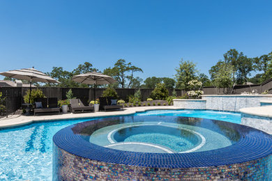 Large island style backyard custom-shaped natural hot tub photo in Sacramento with decking