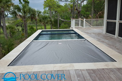 Inspiration for a mid-sized coastal side yard rectangular infinity pool remodel in Charleston with decking