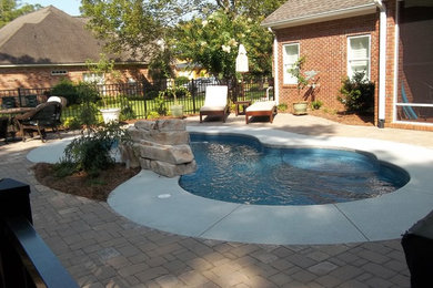 Pool fountain - small contemporary backyard custom-shaped natural pool fountain idea in Other with decking