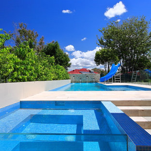 Large contemporary backyard l-shaped pool in Sydney with a hot tub.