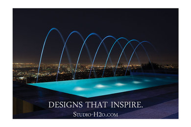 Mid-sized minimalist backyard tile and rectangular infinity pool fountain photo in Los Angeles