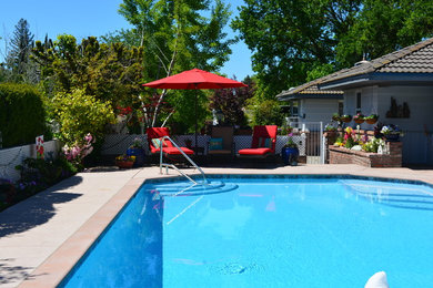 Large elegant side yard stamped concrete and custom-shaped pool photo in Sacramento