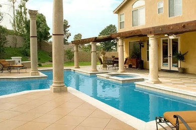 На фото: большой естественный бассейн произвольной формы на заднем дворе в стиле ретро с фонтаном и покрытием из бетонных плит с