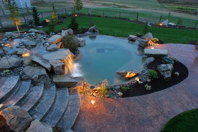Example of a tuscan backyard stamped concrete and custom-shaped pool fountain design in Seattle