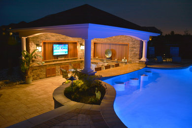 Diseño de casa de la piscina y piscina de tamaño medio a medida en patio trasero con adoquines de hormigón