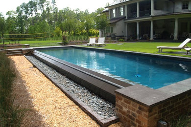 Pool - large contemporary backyard stone and rectangular lap pool idea in New Orleans