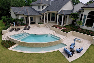 Inspiration for a small contemporary backyard custom-shaped and concrete paver infinity pool house remodel in New Orleans