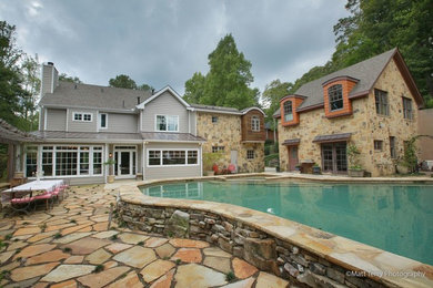 Foto de piscinas y jacuzzis alargados de estilo americano extra grandes a medida en patio trasero con adoquines de piedra natural
