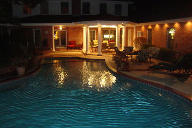Pool - large traditional backyard stone and custom-shaped lap pool idea in Oklahoma City