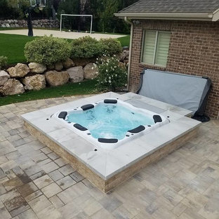 Foto de piscinas y jacuzzis tradicionales, de tamaño medio, en patio trasero, con adoquines de piedra natural