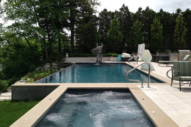 Idée de décoration pour une piscine à débordement et arrière minimaliste de taille moyenne et rectangle avec un toboggan et des pavés en béton.