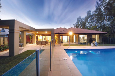 Стильный дизайн: большой прямоугольный бассейн на заднем дворе в современном стиле с мощением тротуарной плиткой - последний тренд