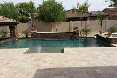 Foto de casa de la piscina y piscina actual grande rectangular en patio trasero con adoquines de piedra natural