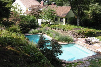 Cette image montre une piscine naturelle et arrière rustique de taille moyenne et sur mesure avec des pavés en béton.