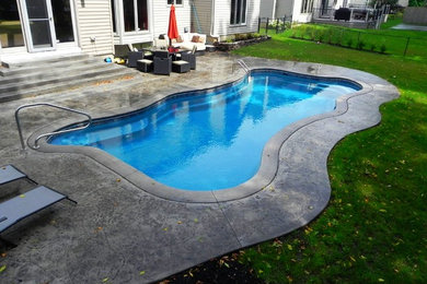 Idee per una grande piscina naturale stile americano personalizzata dietro casa con pavimentazioni in pietra naturale