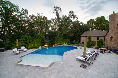 Inspiration for a large contemporary backyard custom-shaped infinity pool fountain remodel in Other