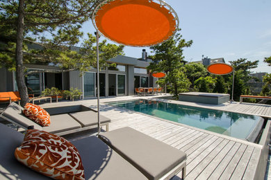 Modelo de piscinas y jacuzzis infinitos retro de tamaño medio rectangulares en patio trasero con entablado