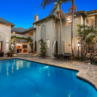 Design ideas for a mediterranean backyard custom-shaped pool in Sydney with a hot tub and natural stone pavers.