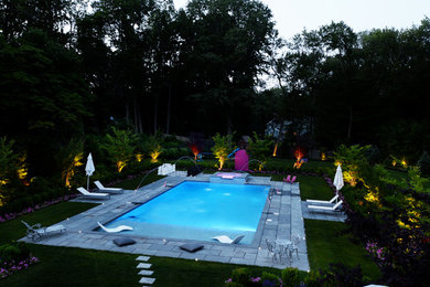 Pool fountain - modern backyard concrete paver and rectangular pool fountain idea in New York