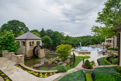 Geräumiger Klassischer Infinity-Pool hinter dem Haus in individueller Form mit Wasserspiel und Natursteinplatten in Dallas