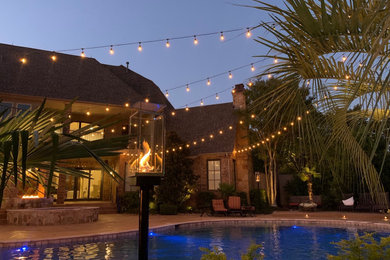 Example of a large island style backyard pool house design in Dallas