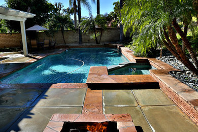 Foto de piscinas y jacuzzis naturales clásicos grandes rectangulares en patio trasero con losas de hormigón