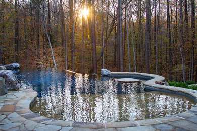 Example of a large mountain style backyard stone and custom-shaped infinity pool fountain design in Raleigh