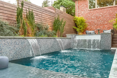 Diseño de piscina con fuente infinita moderna de tamaño medio rectangular en patio con losas de hormigón