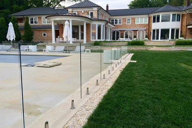Foto de piscina natural contemporánea grande rectangular en patio trasero con suelo de baldosas