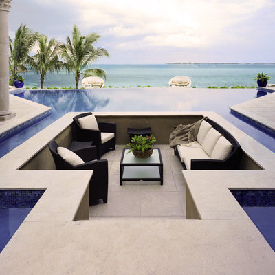Huge elegant backyard tile and custom-shaped infinity pool photo in Other