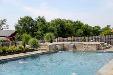 Modelo de piscinas y jacuzzis alargados mediterráneos de tamaño medio rectangulares en patio trasero con adoquines de piedra natural