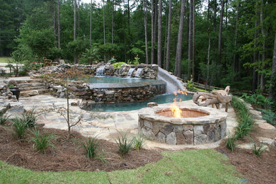Inspiration for a large tropical backyard stone and custom-shaped water slide remodel in Atlanta
