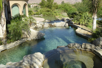 Large tuscan backyard concrete and custom-shaped hot tub photo in Orange County
