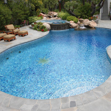 Free-Form Radius Bisazza Glass Mosaic Pool and Natural Stone Overflow Spa